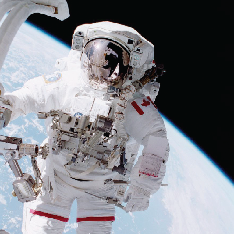 A Canadian astronaut goes on a space walk with planet earth in the background.