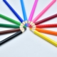 picture of colored pencils arranged in a rainbow arch