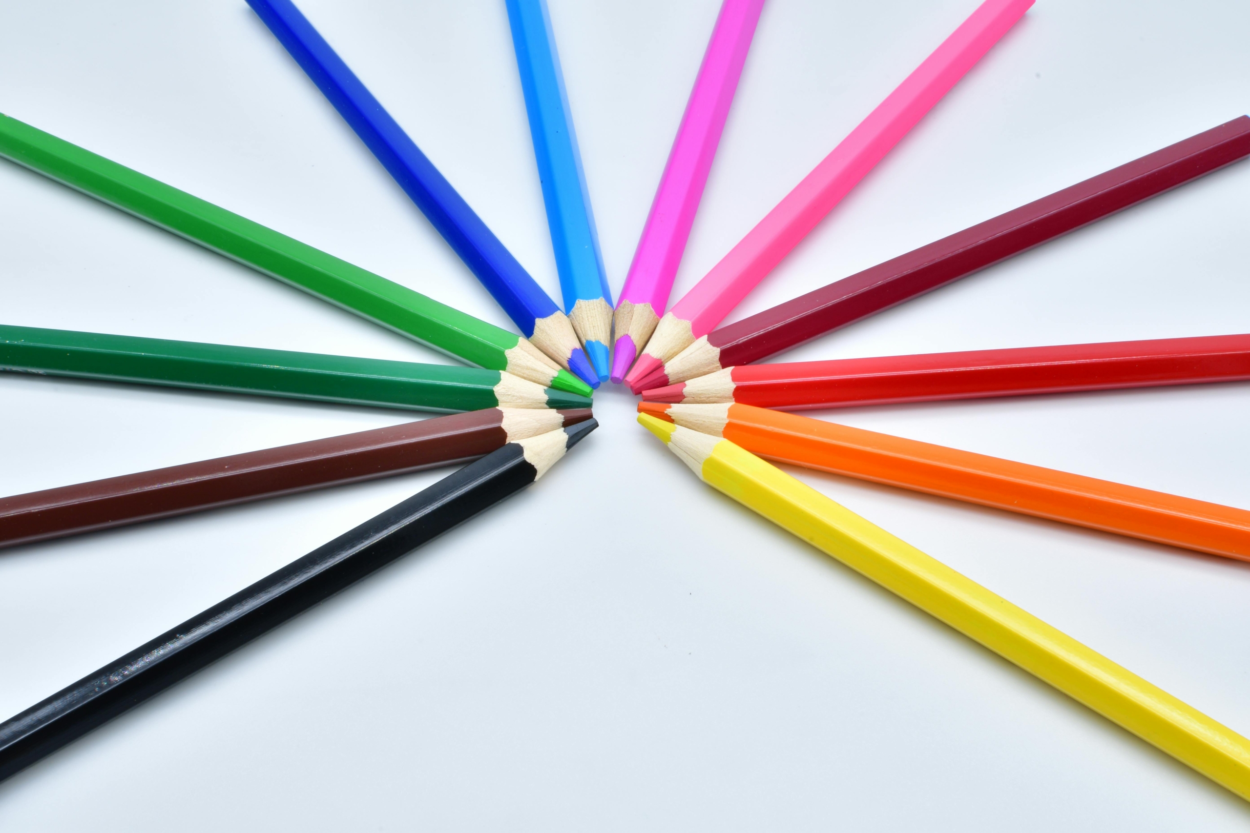 picture of colored pencils arranged in a rainbow arch