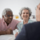A smiling older couple talks with an advisor in a suit.