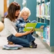 Boy sits on teacher's lap reading a book together in front of bookshelves.