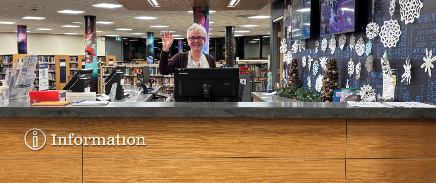 Librarian at welcome desk of New Westminster Public Library's Main Branch.