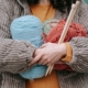 Person holding 3 large bundles of yarn in front of them.