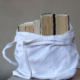 A white, canvas tote bag filled with books.
